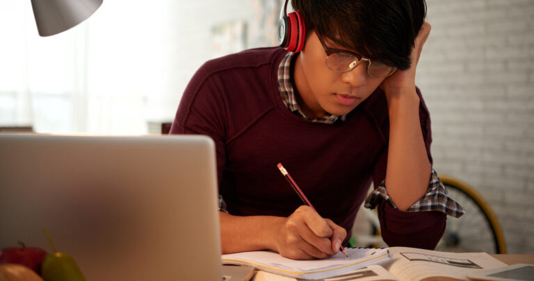 Writing to be heard: image of man with headphones writing